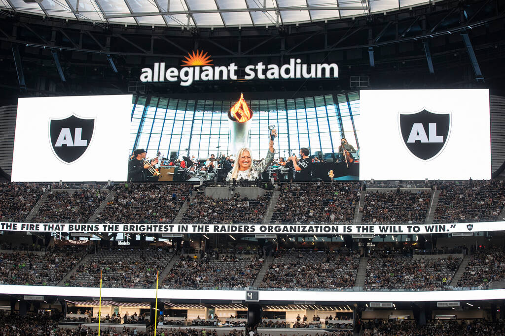 Dr. Mariam Adelson lights the Al Davis Memorial Torch before the start of an NFL preseason foot ...