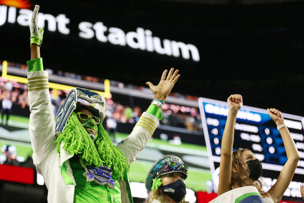 Fans celebrate a touchdown by the Seattle Seahawks in the third quarter of a NFL preseason game ...