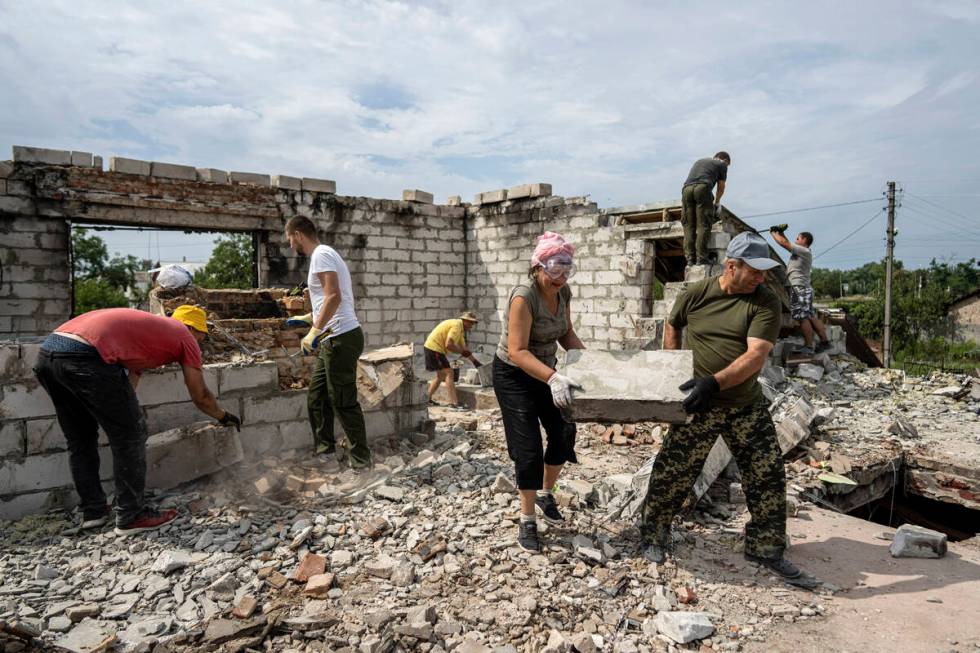 Volunteers clear rubble on the second floor of Zhanna and Serhiy Dynaeva's house which was dest ...