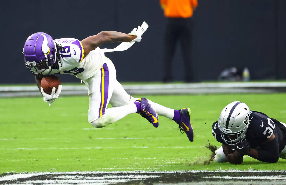 Minnesota Vikings wide receiver Ihmir Smith-Marsette (15) gets tripped up by Raiders safety Dur ...