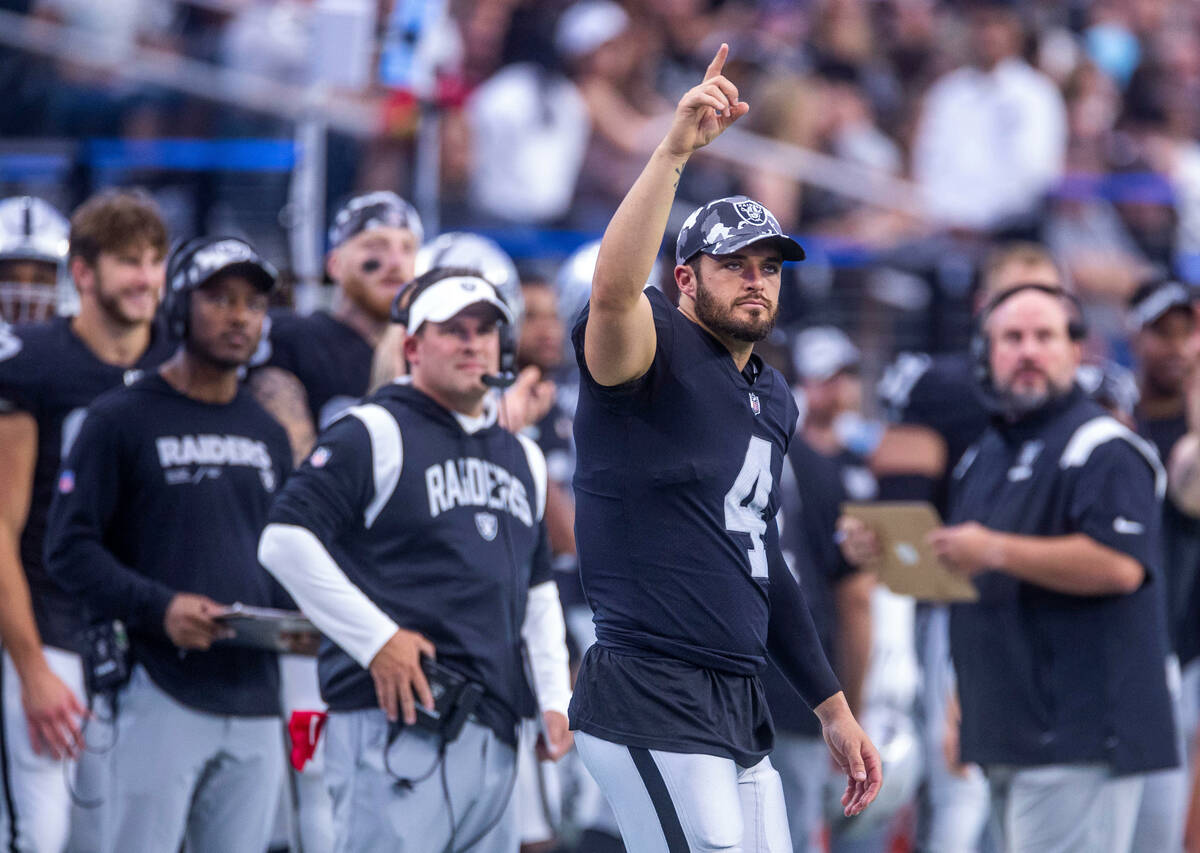 Raiders quarterback Derek Carr (4) signals another score with head coach Josh McDaniels behind ...