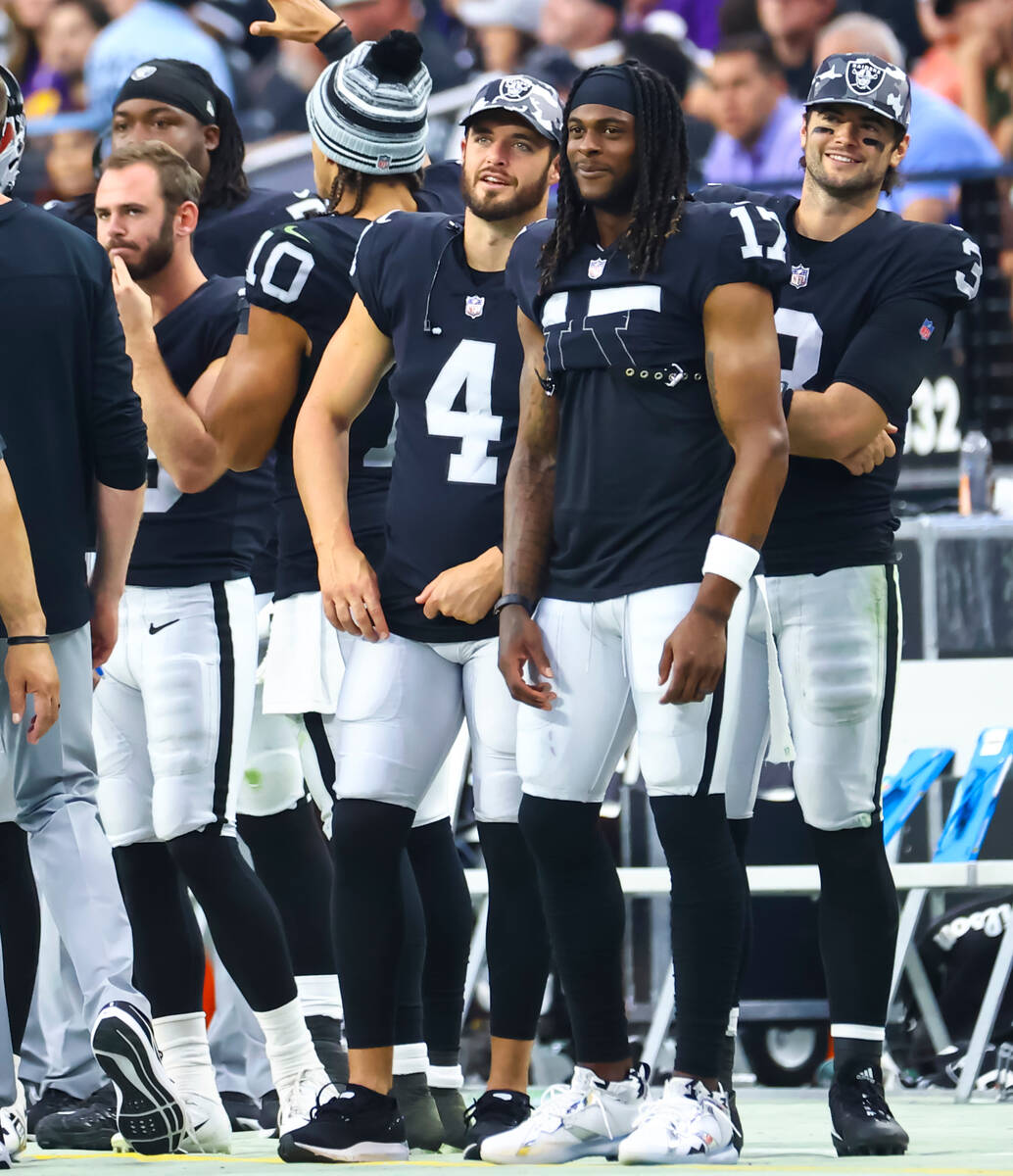 Raiders quarterback Derek Carr (4) and wide receiver Davante Adams look on during the second ha ...