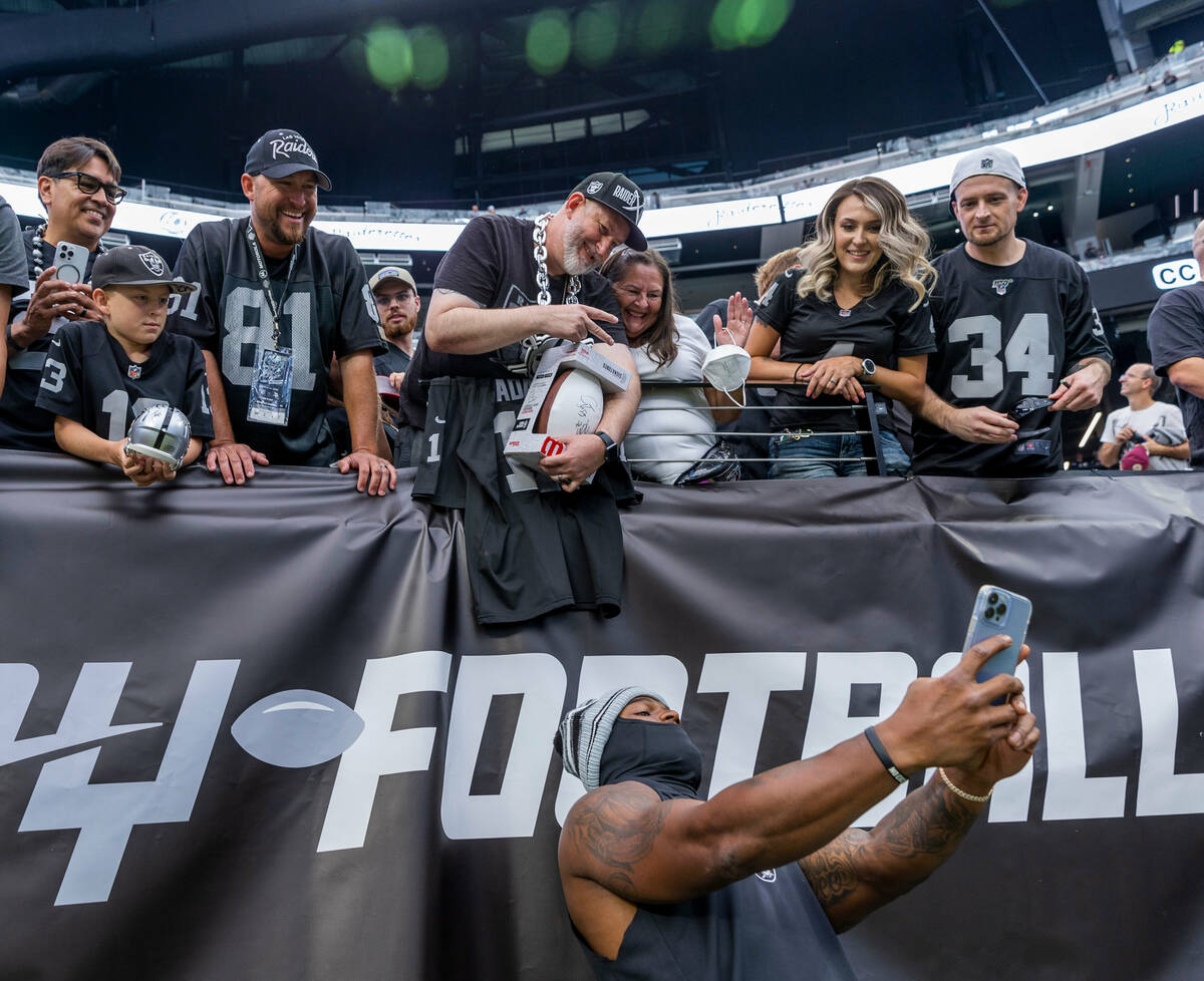 Raiders linebacker Denzel Perryman (52) takes a selfie with fans before the Raiders versus Viki ...