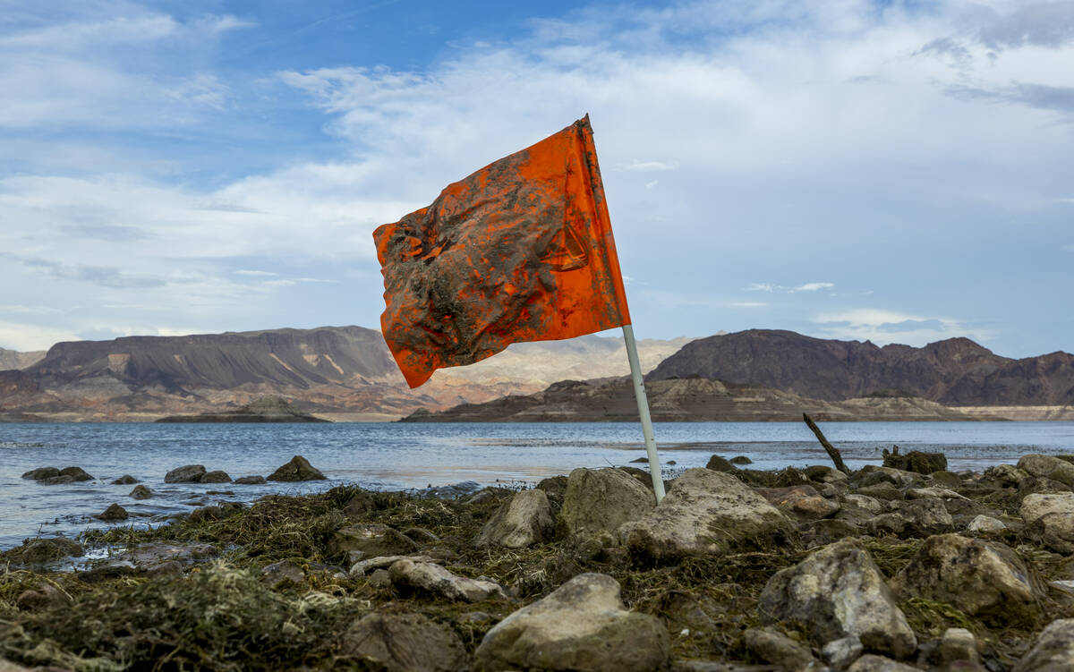An orange flag is stuck along the shoreline near where a body was found at Swim Beach within th ...