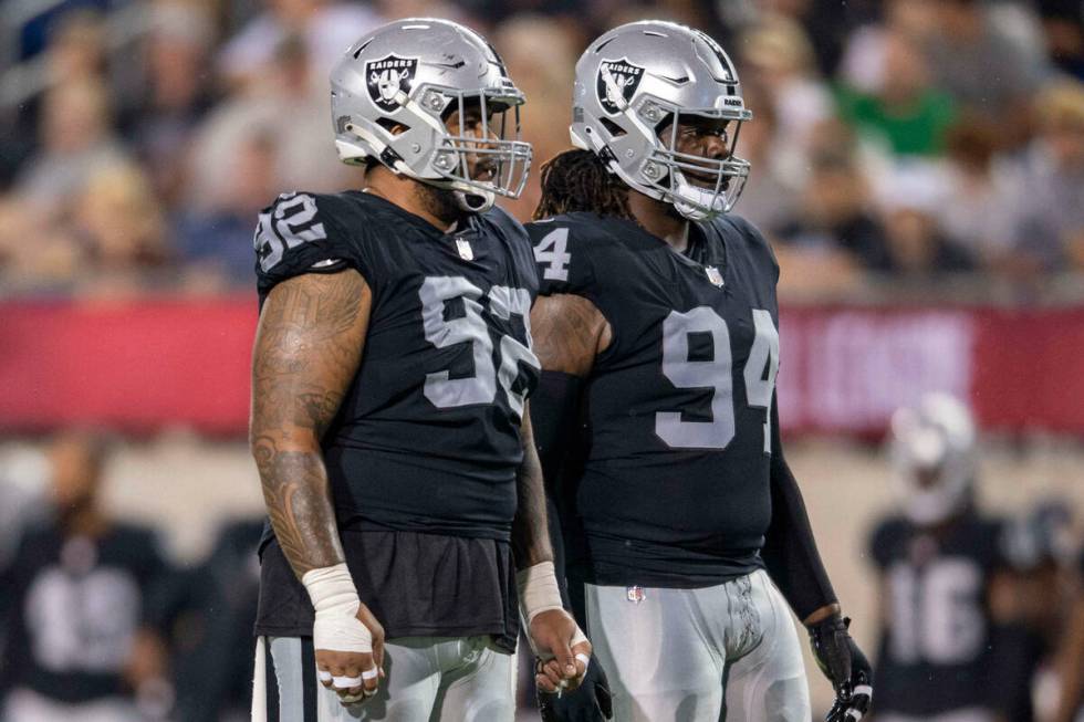 Las Vegas Raiders defensive tackle Kyle Peko and defensive tackle Vernon Butler stand during th ...