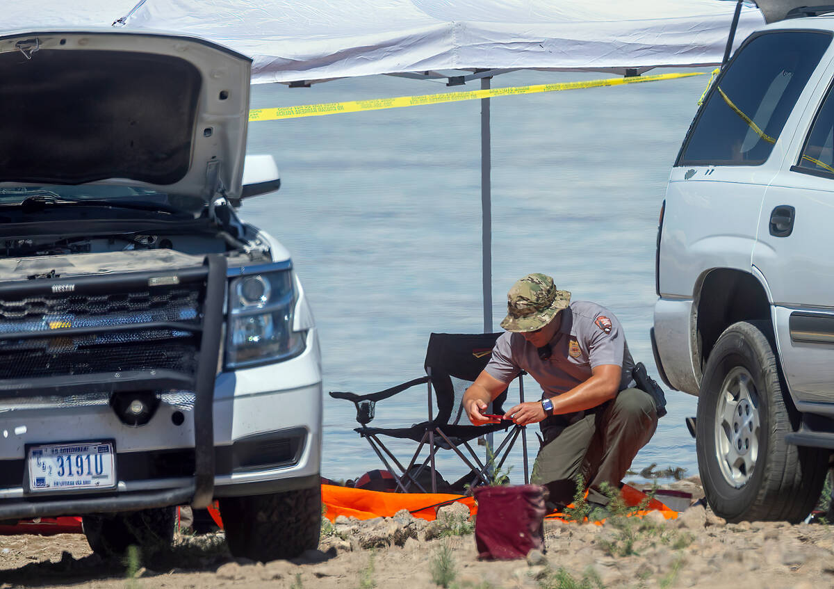 A National Park Ranger takes a photo of items on a tarp as authorities are assessing what were ...