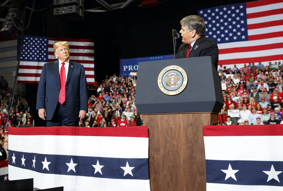 Donald Trump listens Fox News' Sean Hannity speak during a rally at Show Me Center, Monday, Nov ...