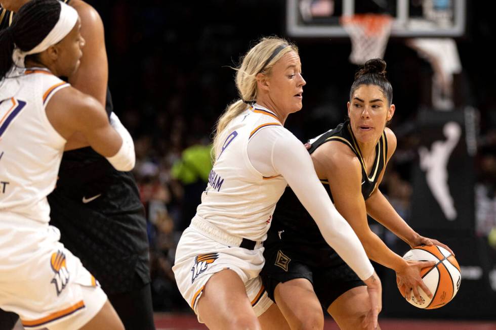 Las Vegas Aces guard Kelsey Plum (10) drives around Phoenix Mercury guard Sophie Cunningham (9) ...