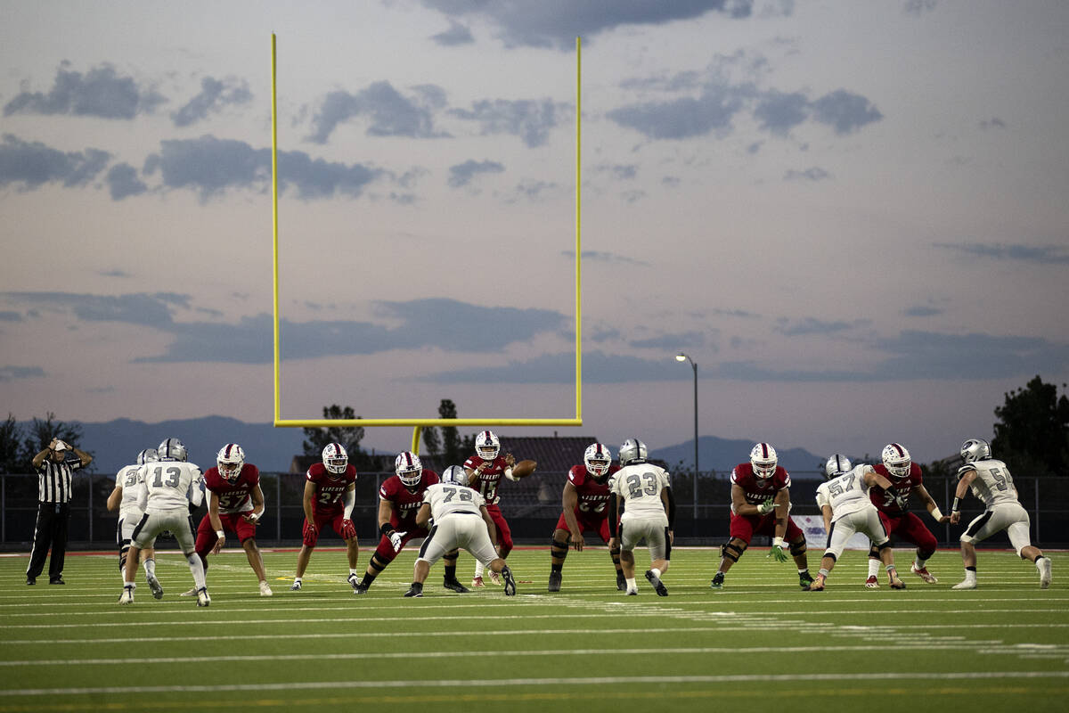 Liberty receives the snap during the second half of a Class 5A high school football game agains ...