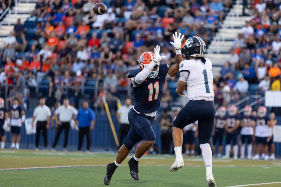 Bishop Gorman's Quincy Davis (11) pressures Corner Canyon's quarterback Issac Wilson (1) during ...