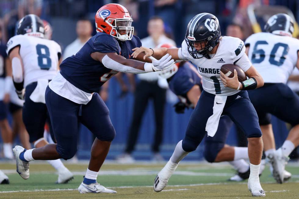 Bishop Gorman's Jayden House (8) pressures Corner Canyon's quarterback Issac Wilson (1) during ...