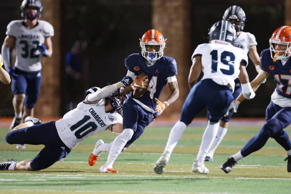 Bishop Gorman's Jaylon Edmond (14) evades a tackle from Corner Canyon's Bridger Davies (10) dur ...