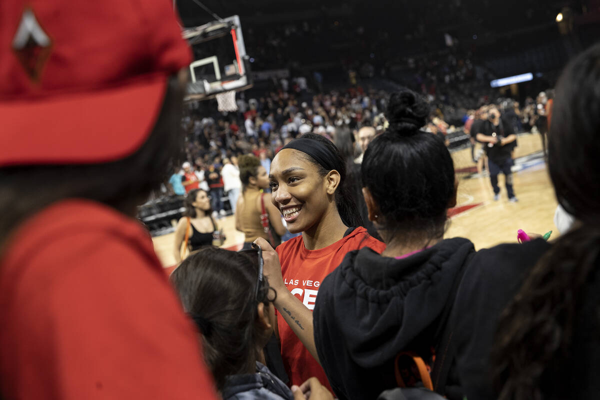 Las Vegas Aces forward A'ja Wilson, center, signs autographs for fans after winning a WNBA play ...