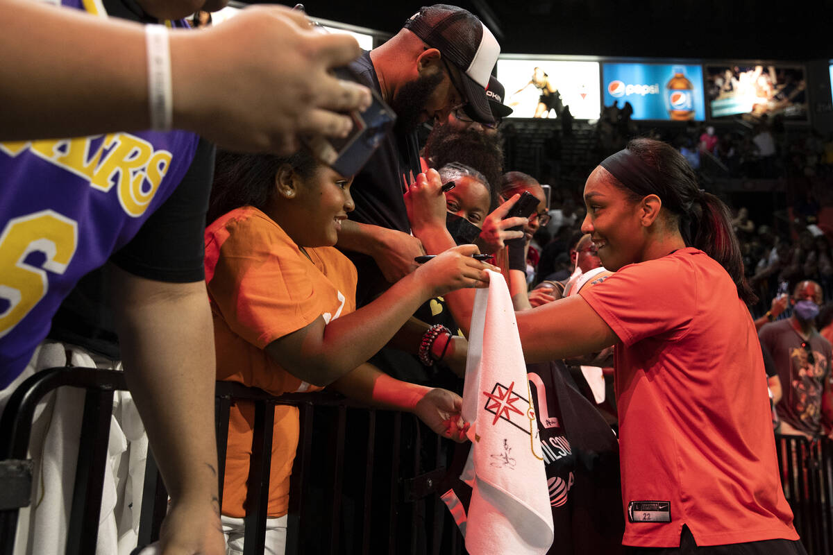 Las Vegas Aces forward A'ja Wilson, center, signs autographs for fans after winning a WNBA play ...