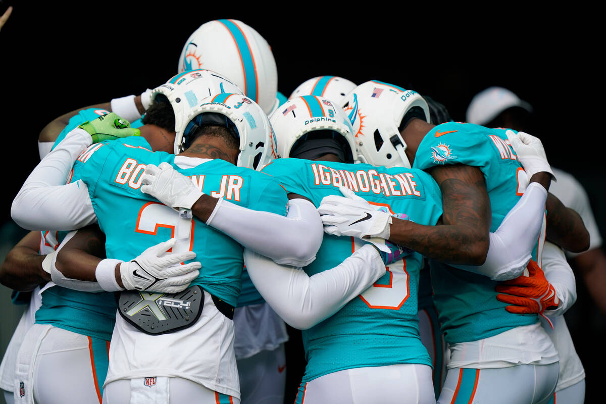 Miami Dolphins players huddle before warming up at a NFL preseason football game against the La ...