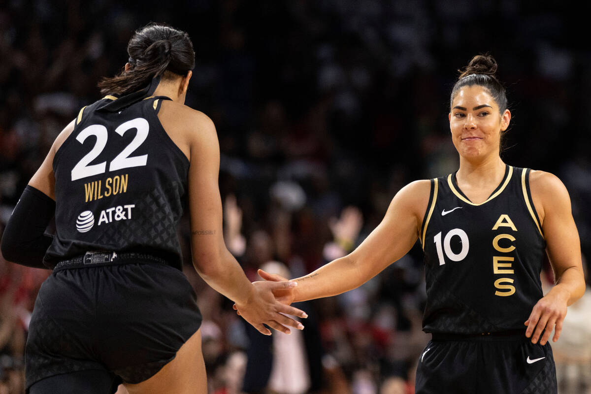 Las Vegas Aces guard Kelsey Plum (10) slaps hands with Las Vegas Aces forward A'ja Wilson (22) ...