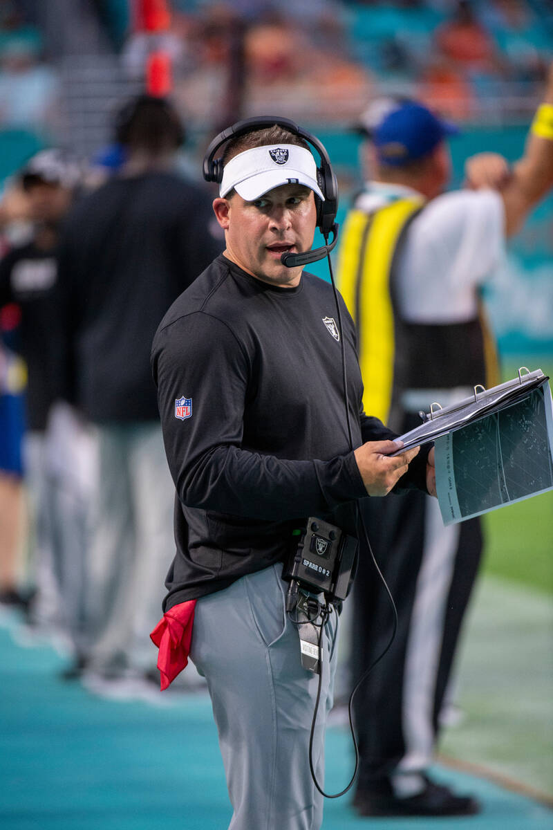 Las Vegas Raiders head coach Josh McDaniels talks on the headset on the sidelines during an NFL ...