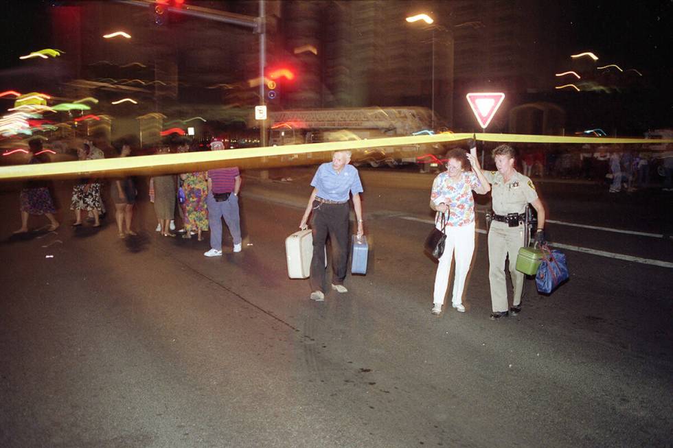 A Metropolitan Police officer helps Gilbert and Dorothy Scheerings of Tucson, Arizona evacuate ...