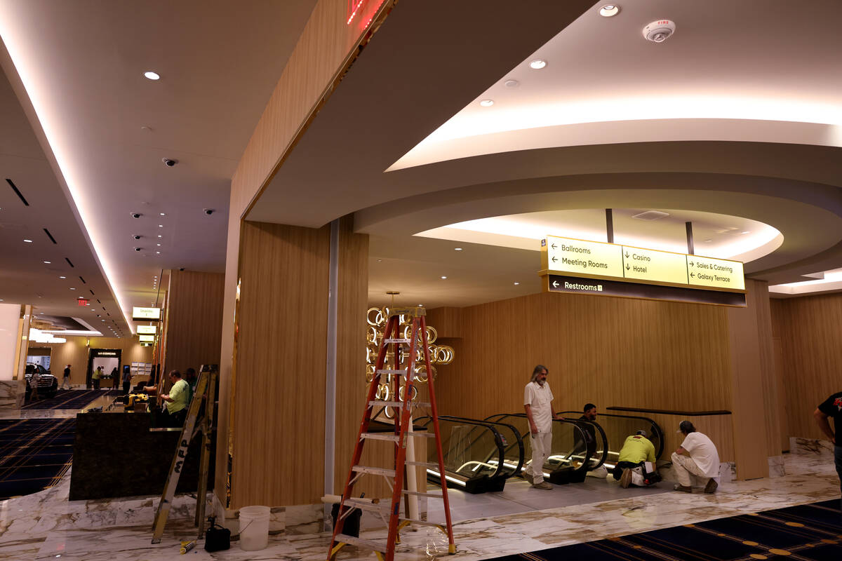 Workers put the finishing touches on the pre-function area at the new meetings and conventions ...