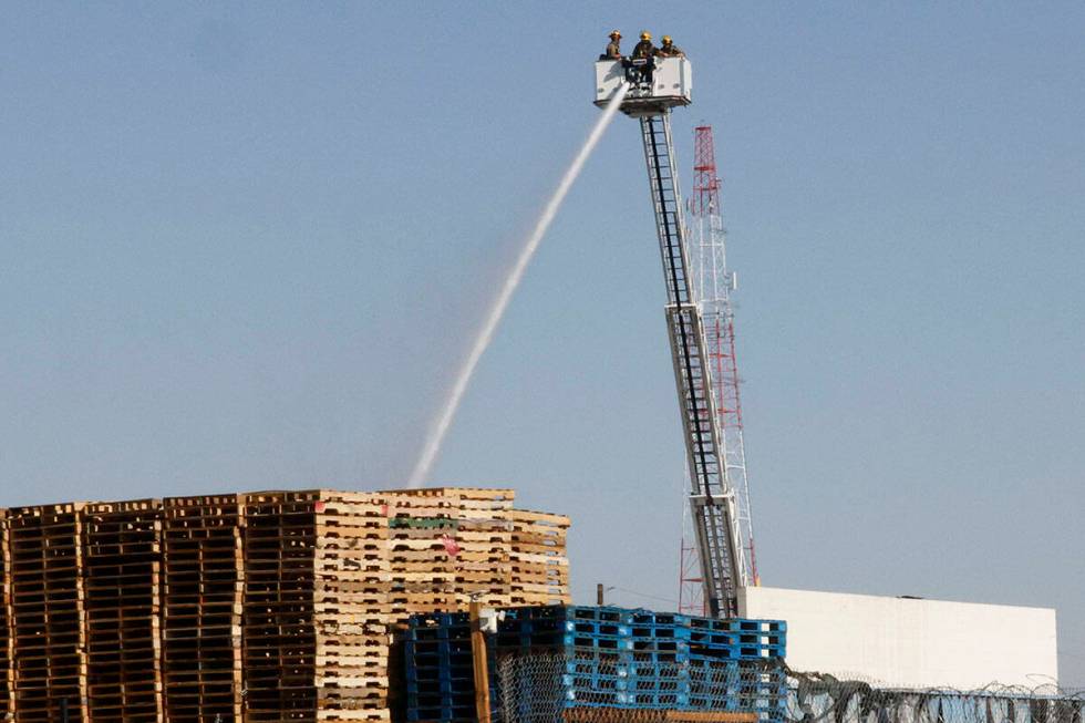 Firefighters try to extinguish a fire near Procyon Street, Tuesday, Aug. 23, 2022, in Las Vegas ...