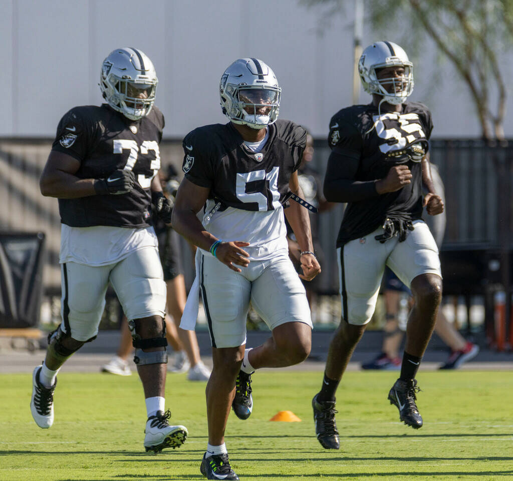Raiders defensive end Malcolm Koonce (51) runs on the field with defensive tackle Matthew Butle ...