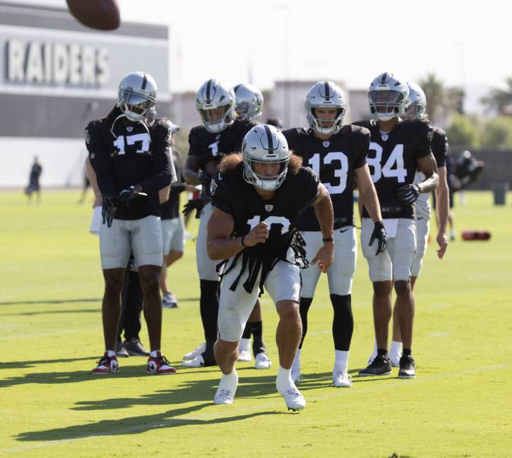 Raiders wide receiver Mack Hollins (10) runs to make a catch as wide receivers Davante Adams (1 ...