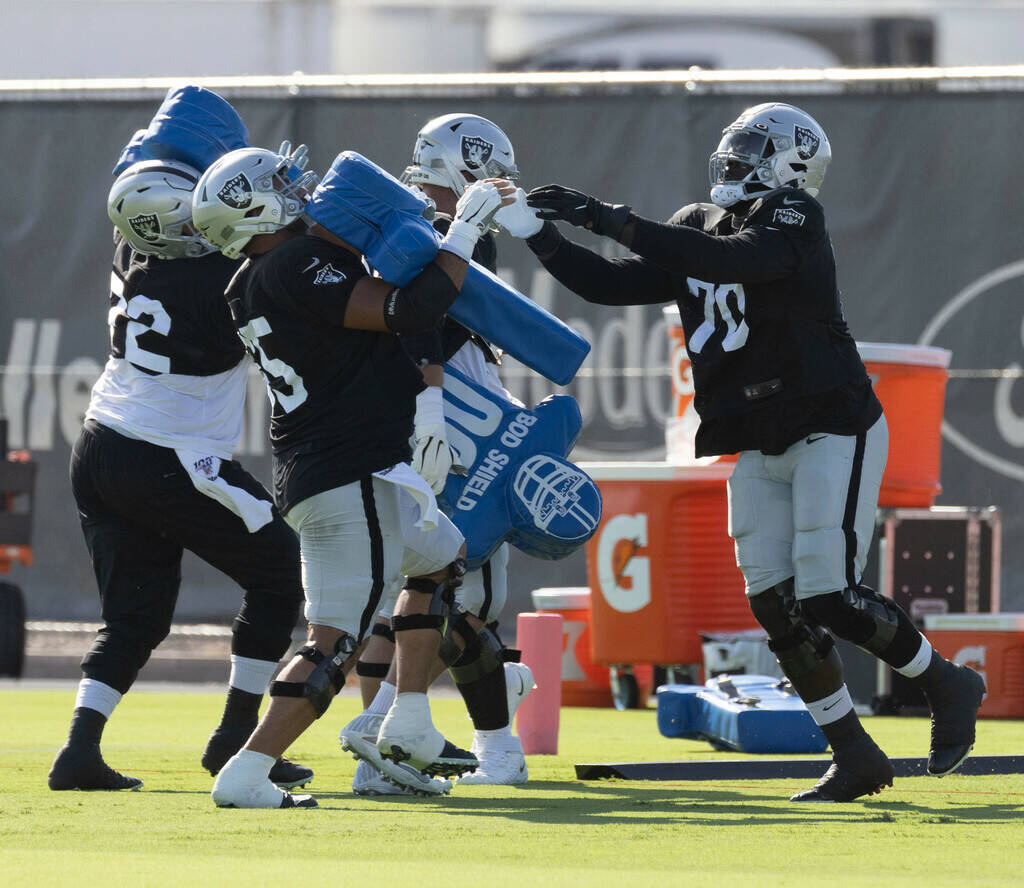 Raiders center Hroniss Grasu (65) is pressured by offensive tackle Alex Leatherwood (70) during ...