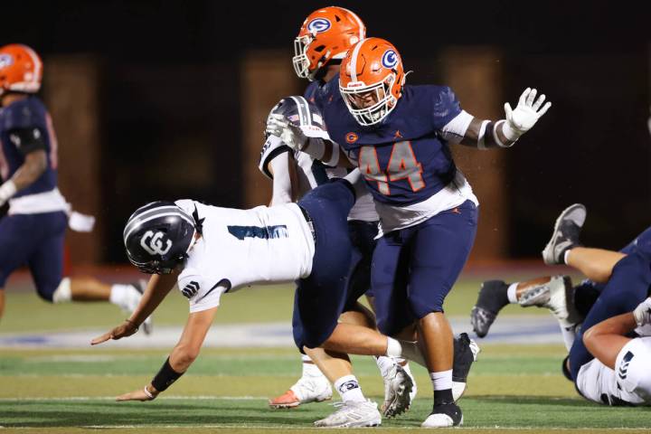 Bishop Gorman's Aiden McComber (44) gets a late hit on Canyon's quarterback Issac Wilson (1) du ...