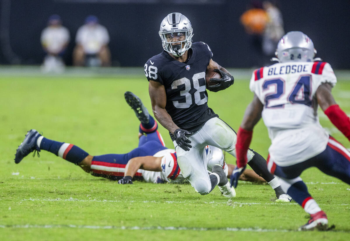 Raiders running back Brittain Brown (38) cuts back versus the New England Patriots safety Joshu ...