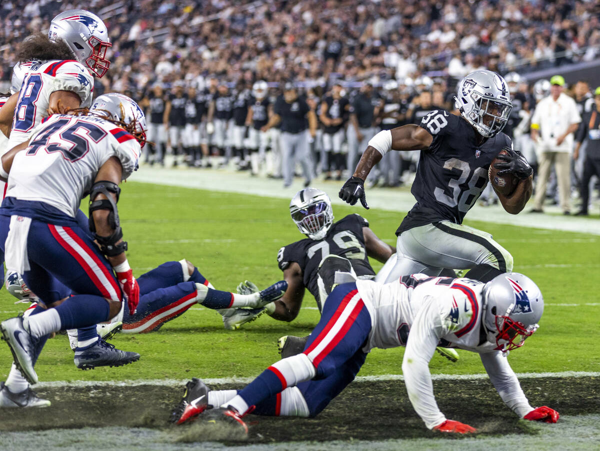 Raiders running back Brittain Brown (38) scampers into the end zone as New England Patriots saf ...
