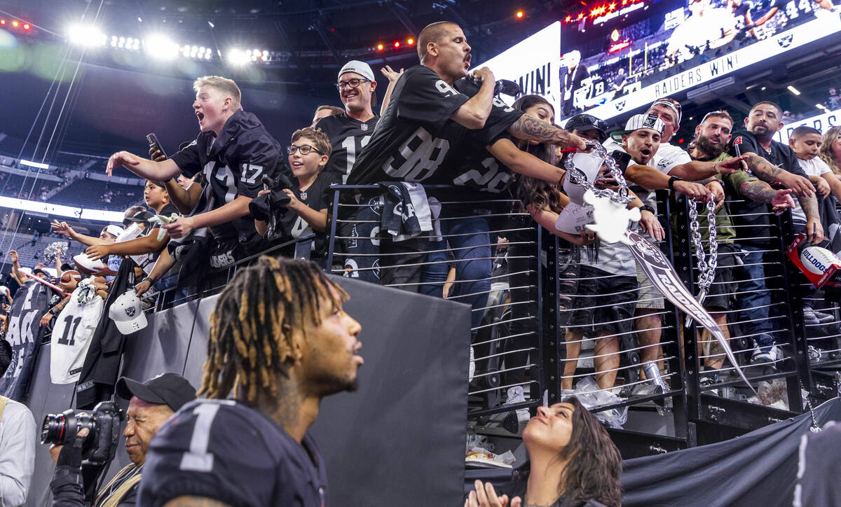 Raiders fans call to players including wide receiver Tyron Johnson (1) in hopes of receiving a ...