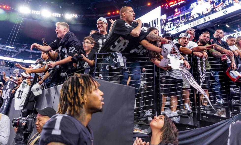 Raiders fans call to players including wide receiver Tyron Johnson (1) in hopes of receiving a ...