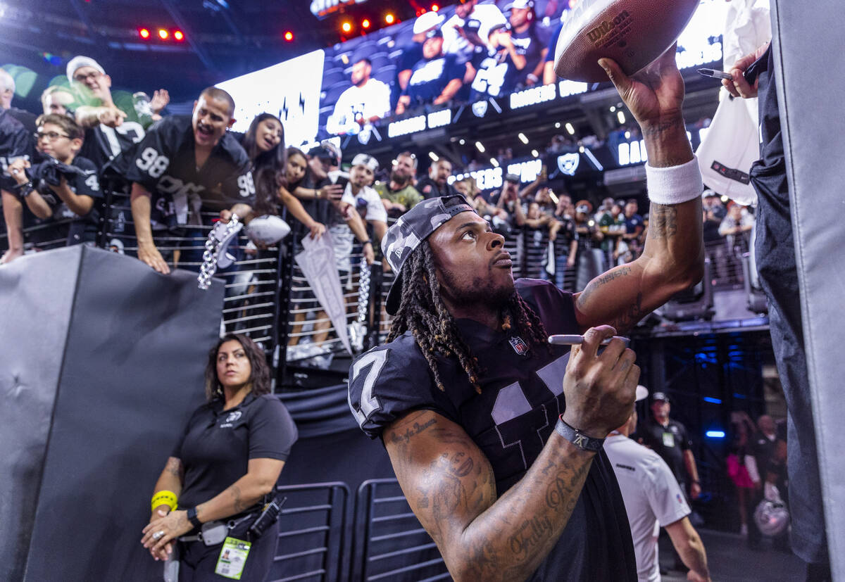 Raiders wide receiver Davante Adams (17) hands back an autographed ball to a fan after defeatin ...