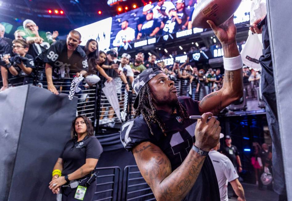 Raiders wide receiver Davante Adams (17) hands back an autographed ball to a fan after defeatin ...