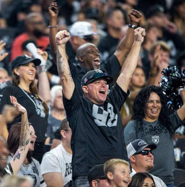 A Raiders fan cheers during the second half of an NFL game against the New England Patriots at ...