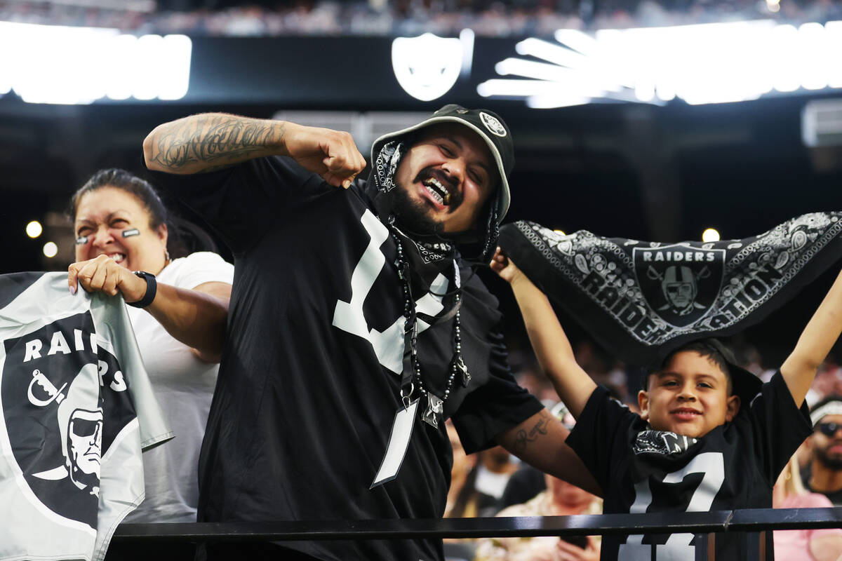 Jesse Guerrero, center, with his son Jacob, 6, of Sunnyvale, Calif., cheer after a Raiders scor ...