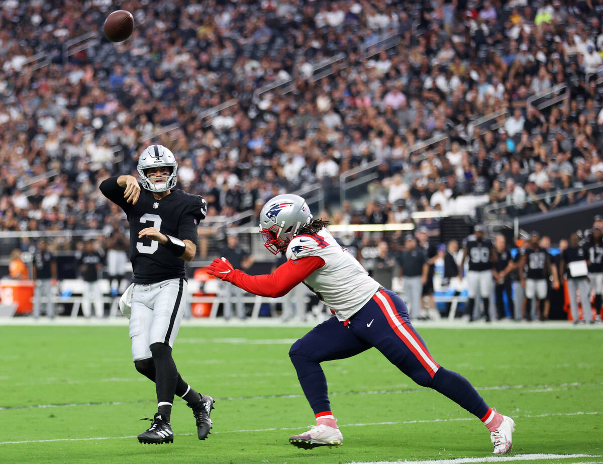 Raiders quarterback Jarrett Stidham (3) throws a ball under pressure from New England Patriots ...