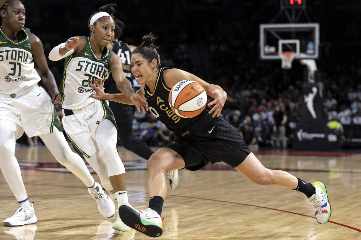 Las Vegas Aces guard Kelsey Plum (10) drives around Seattle Storm guard Briann January (20) and ...
