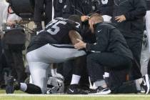 Raiders offensive tackle Brandon Parker (75) is examined by trainers during the first half of t ...