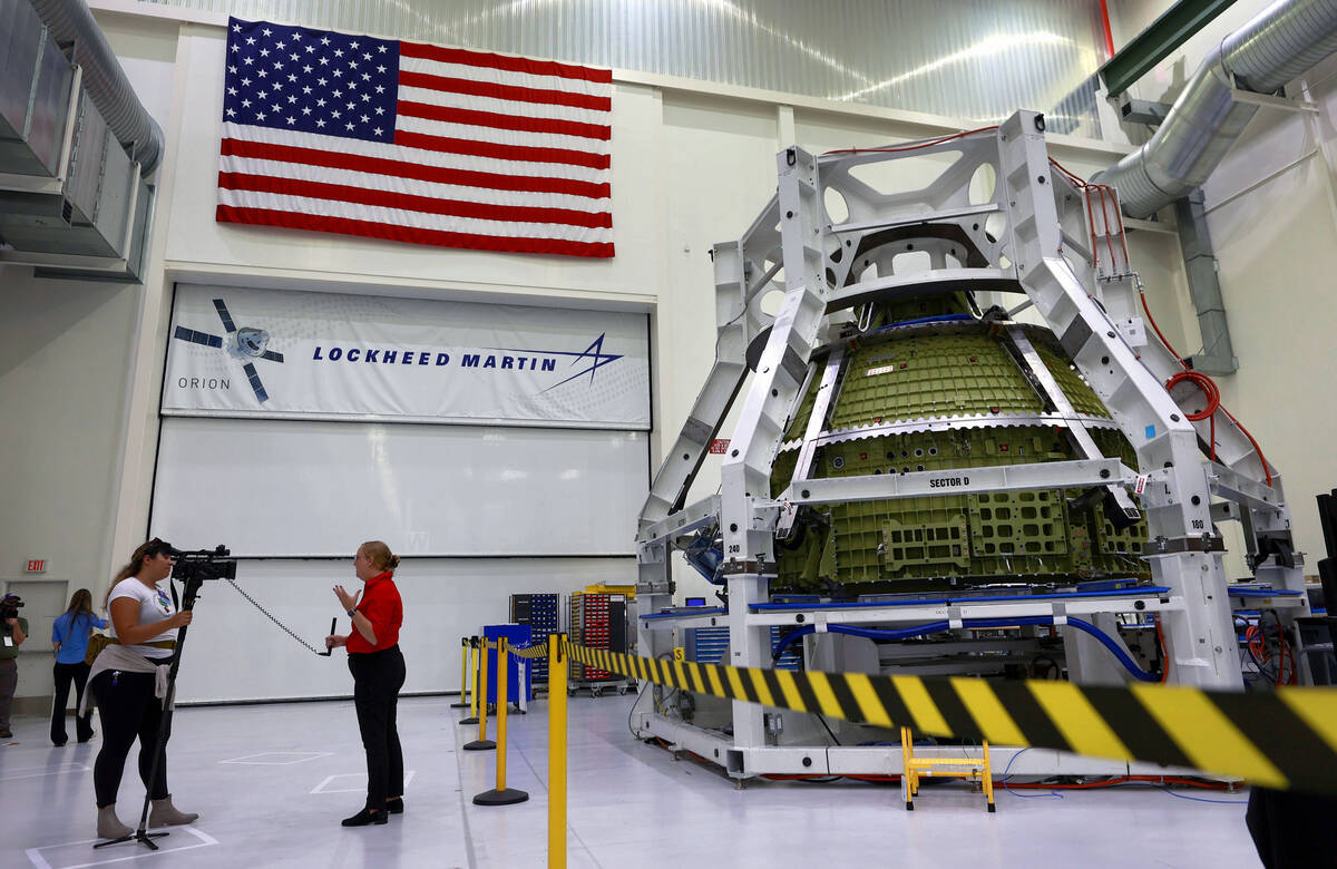 Orion program engineers talk in front of the Artemis III crew capsule being assembled at Kenned ...