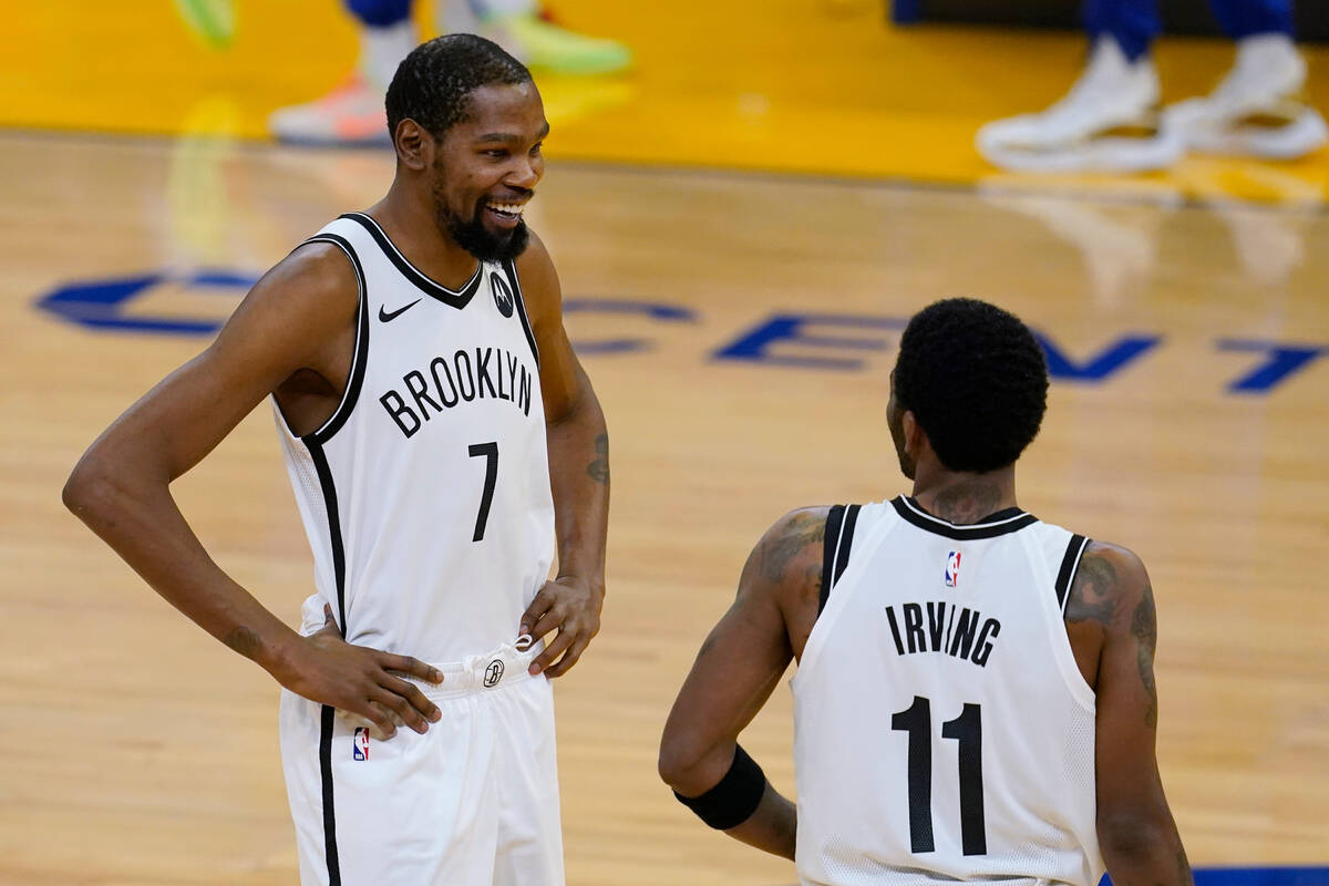 Brooklyn Nets forward Kevin Durant (7) smiles while talking with guard Kyrie Irving (11) before ...