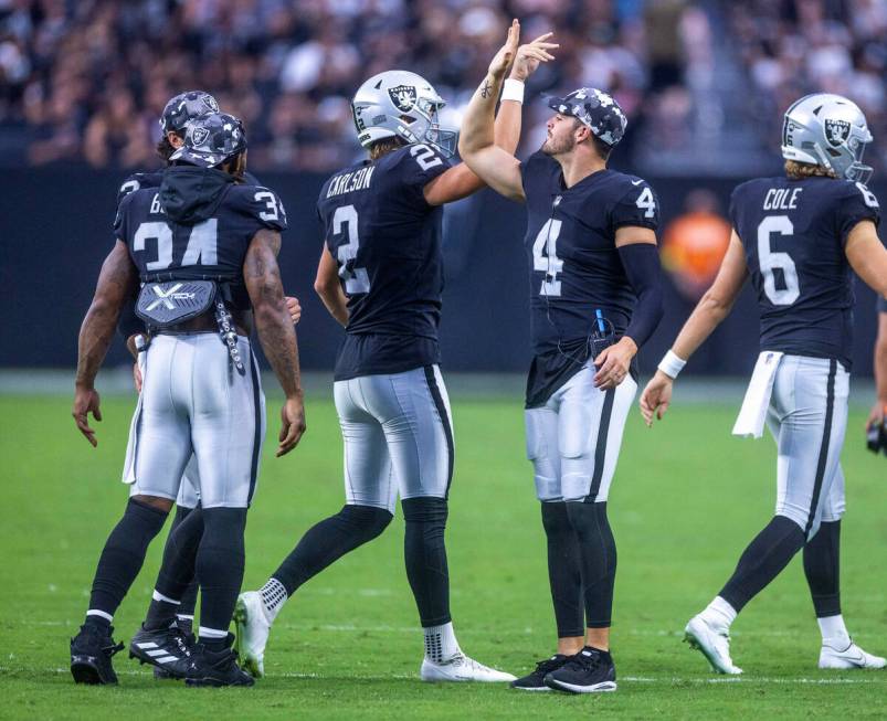 Raiders quarterback Derek Carr (4) congratulates place kicker Daniel Carlson (2) on another sco ...