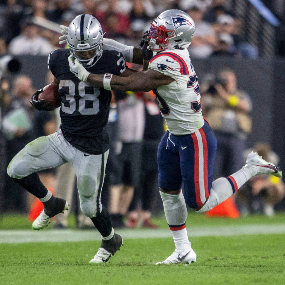 Raiders running back Brittain Brown (38) stiff arms New England Patriots linebacker Mack Wilson ...