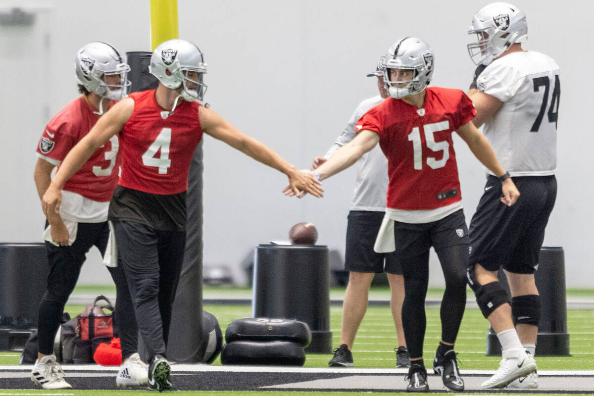 Raiders quarterbacks Derek Carr (4) and Chase Garbers (15) greet each other during practice at ...