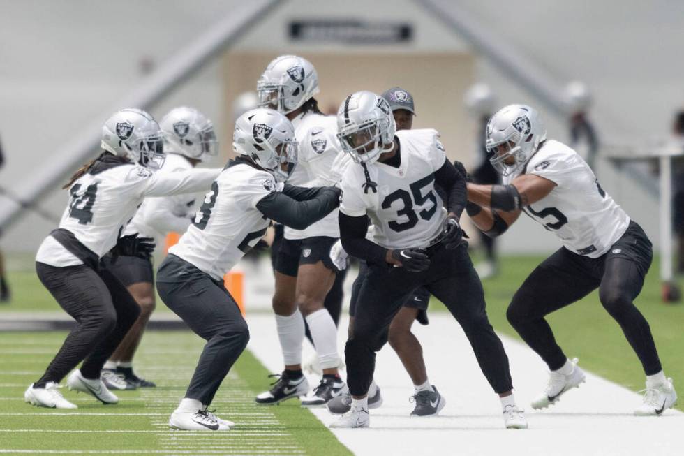 Raiders running back Zamir White (35) works with running back Josh Jacobs (28) and fullback Jak ...