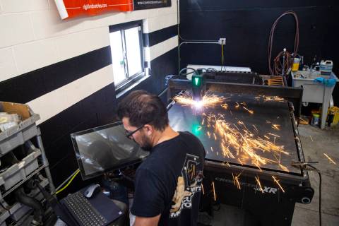 Custom Motor Sports fabricator Dick Bushman (cq) uses a plasma table to cut out a cover for a c ...