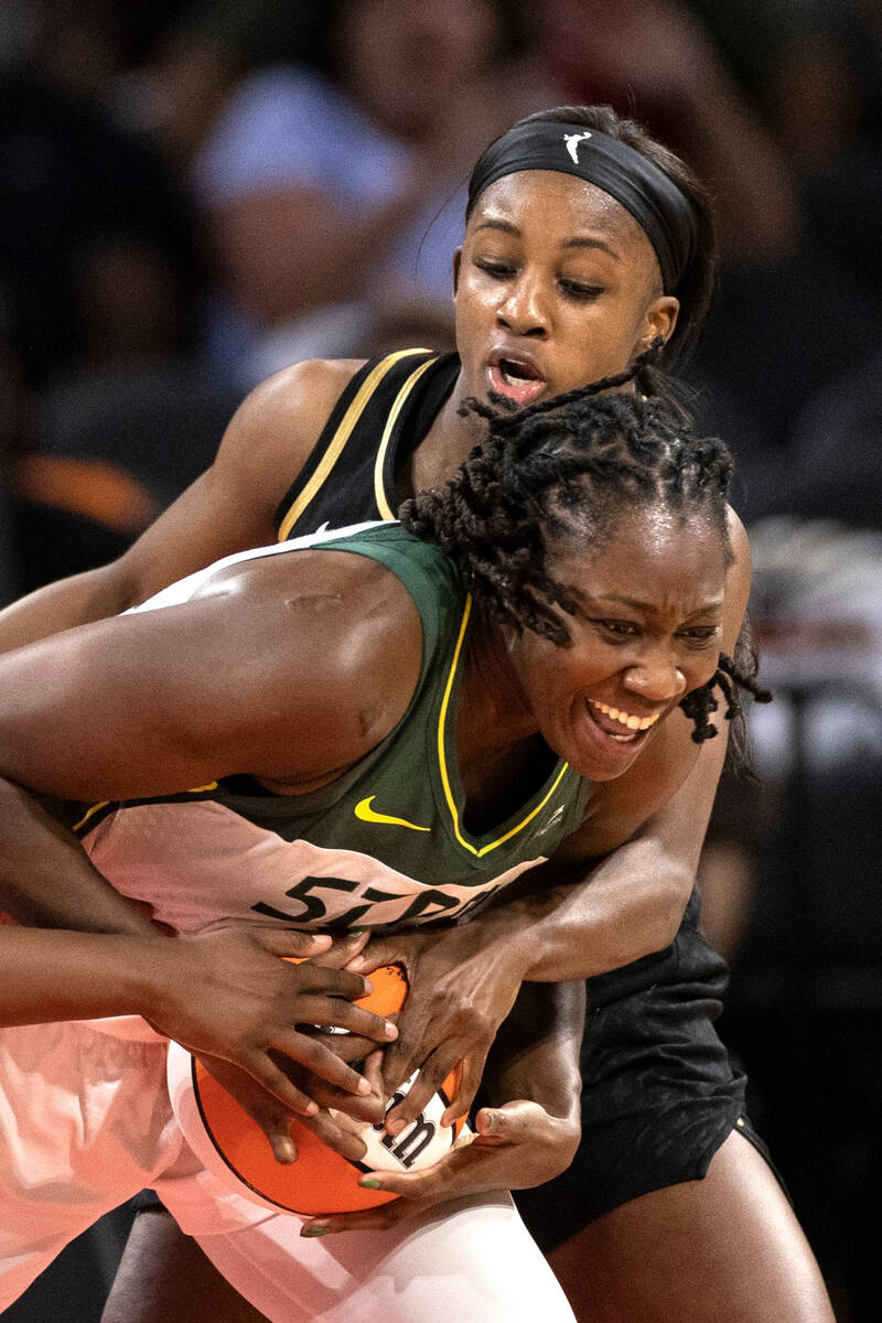 Las Vegas Aces guard Jackie Young (0) and Seattle Storm center Tina Charles (31) compete for po ...