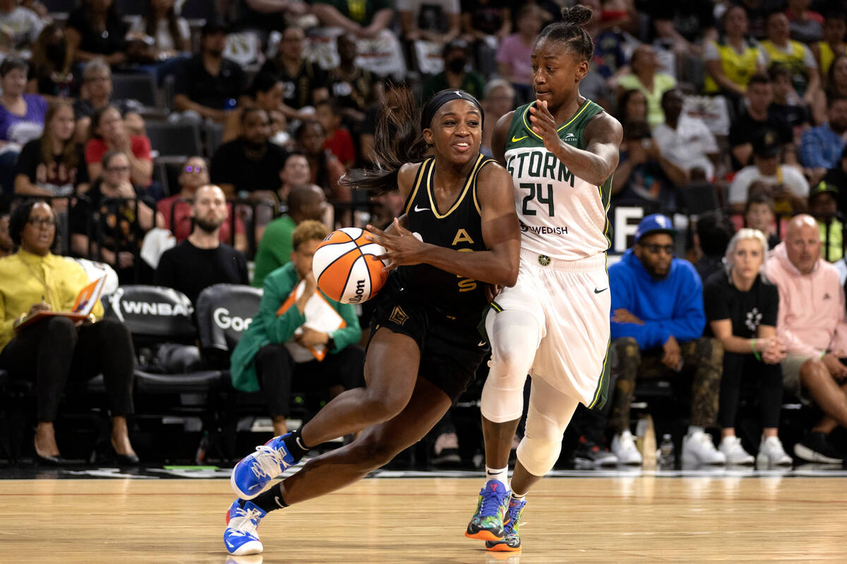 Las Vegas Aces guard Jackie Young (0) drives around Seattle Storm guard Jewell Loyd (24) during ...
