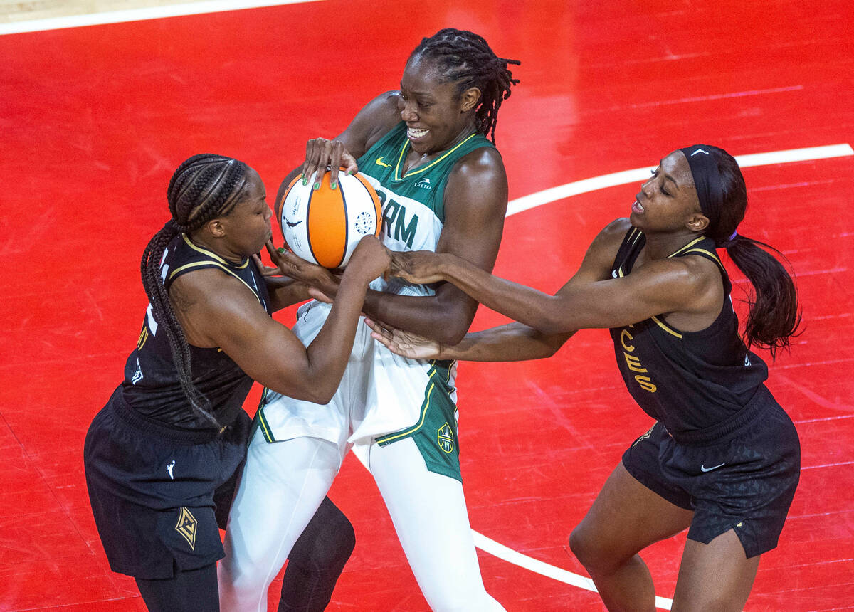 Las Vegas Aces guard Chelsea Gray (12) fights for the ball with Seattle Storm center Tina Charl ...