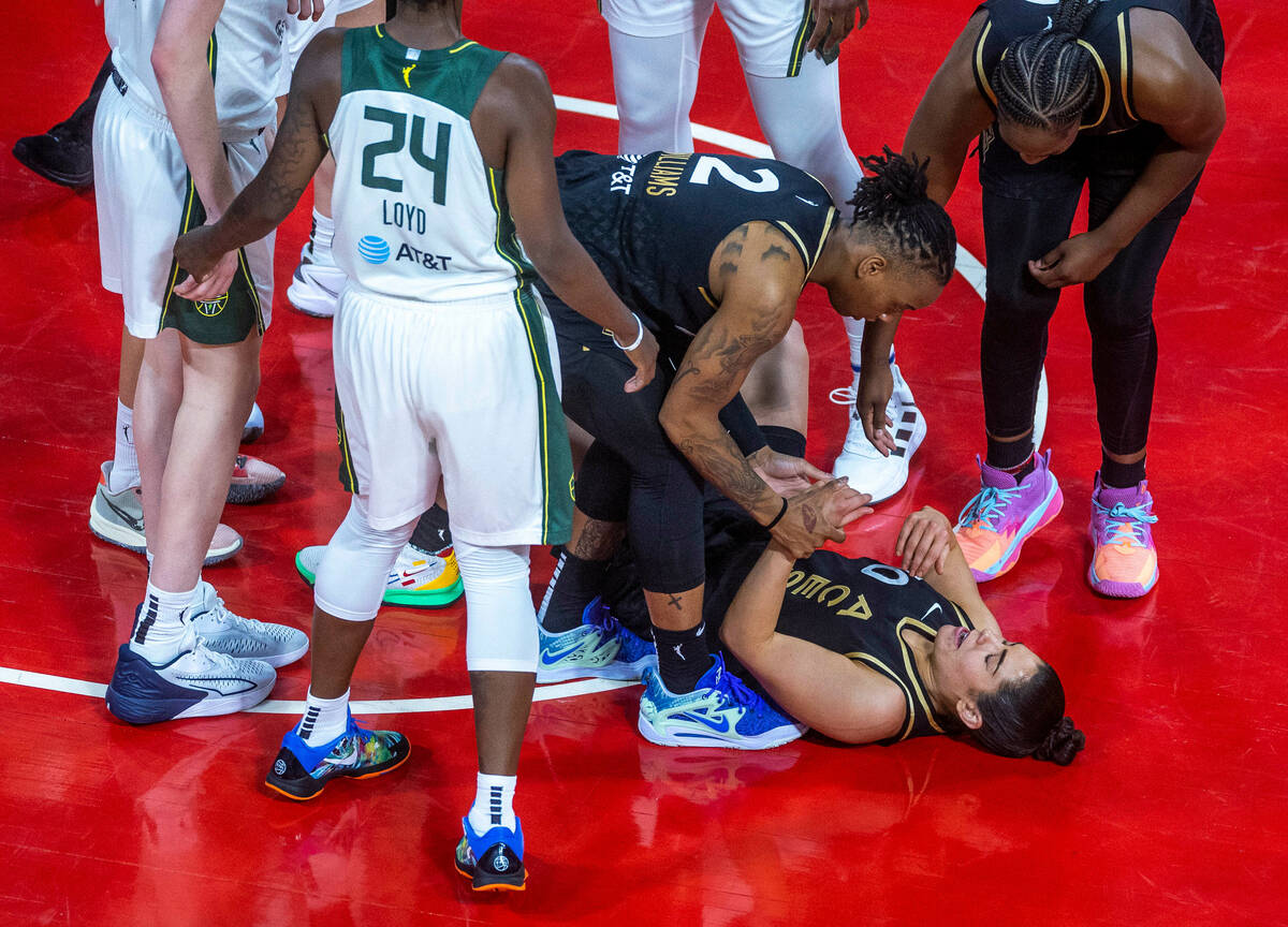 Las Vegas Aces guard Kelsey Plum (10) is checked on by teammate guard Riquna Williams (2) after ...